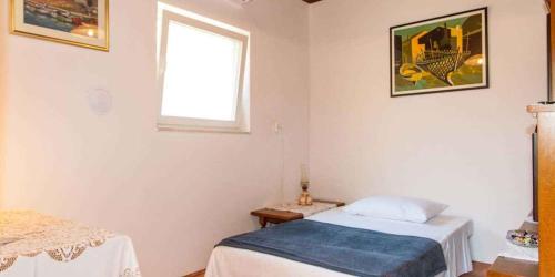 niewielka sypialnia z łóżkiem i oknem w obiekcie Apartment in Mali Losinj 36605 w miejscowości Mali Lošinj