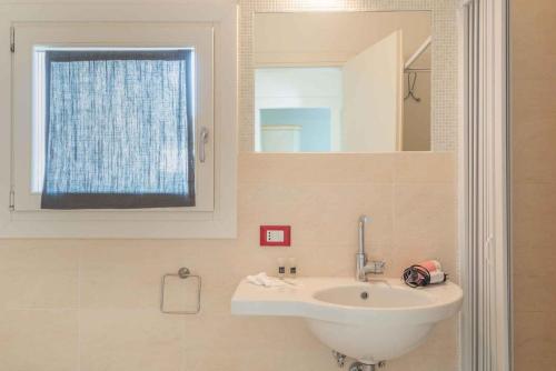 バージャ・サルディニアにあるHoliday home in Baja Sardinia 30356の洗面台と鏡のあるバスルーム