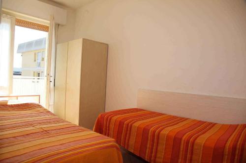 ビビオーネにあるApartments in Bibione 25582のベッドルーム1室(ベッド2台、窓付)