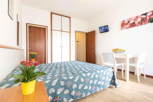 リニャーノ・サッビアドーロにあるApartments in Lignano Sabbiadoro 33368のベッドルーム1室(ベッド1台、テーブル付)、ダイニングルームが備わります。