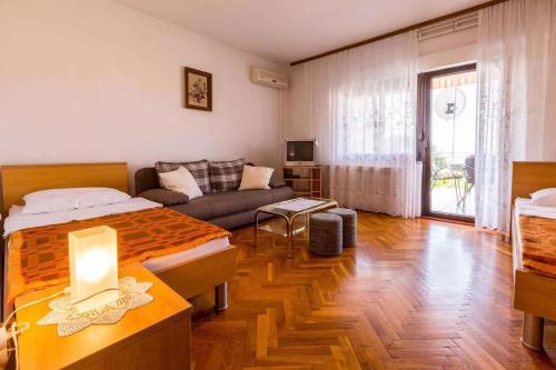 a living room with a bed and a couch at Apartment in Crikvenica 14098 in Dramalj