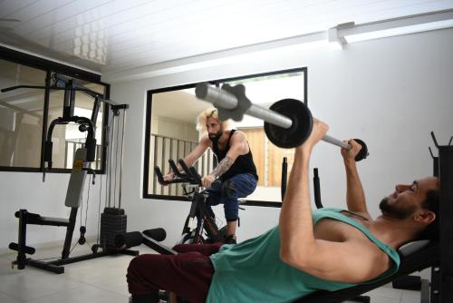 a man lifting a barbell in a gym at Hotel Nova Park in Arauca