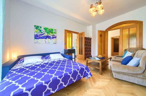 a bedroom with a blue and white bed and a couch at Apartment in Vrbnik/Insel Krk 35995 in Vrbnik