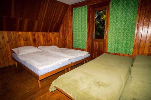 1 dormitorio con 2 camas y ventana en Holiday home Podbanske/Hohe Tatra 26186, en Podbanské