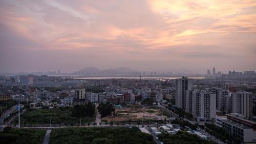 a view of a city at sunset with buildings at C&D Hotel,Xiamen Xiang'an-Late Check Out & Free Welcome Snacks in Xiamen