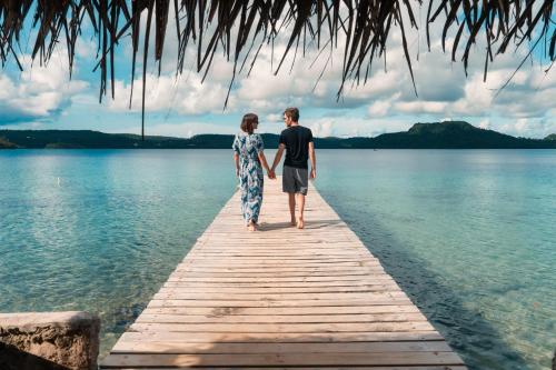 a man and a woman standing on a dock in the water at Mystic Sands in Utungake