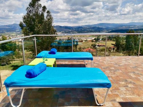 two blue beds on a balcony with a view at Santelmo Casa Hotel Boutique in Paipa