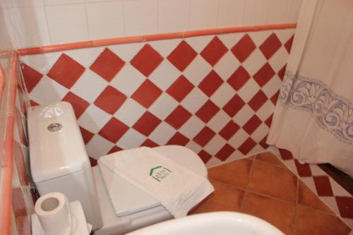 a small bathroom with a white toilet and red and white tiles at Hostal Villa Verde-Adults Only in Deia
