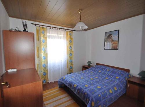 a bedroom with a blue bed and a window at Apartment in Risika - Island Krk 35824 in Risika