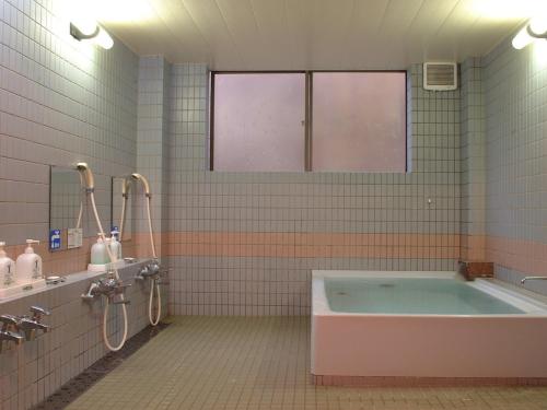 a bathroom with a tub and two sinks at Ono Pension in Iiyama