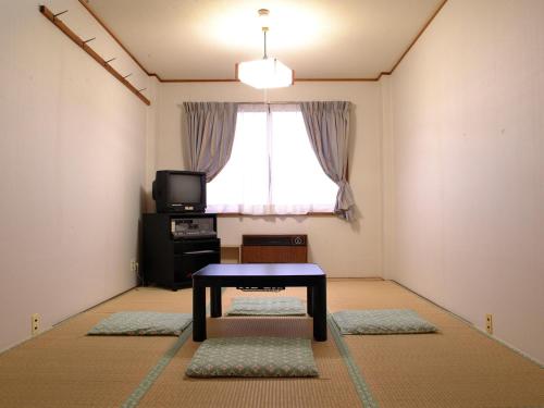 a living room with a table and a window at Ono Pension in Iiyama