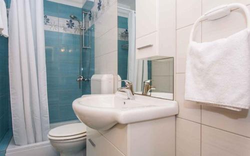 a white bathroom with a sink and a toilet at Apartment in Vrbnik/Insel Krk 35843 in Vrbnik