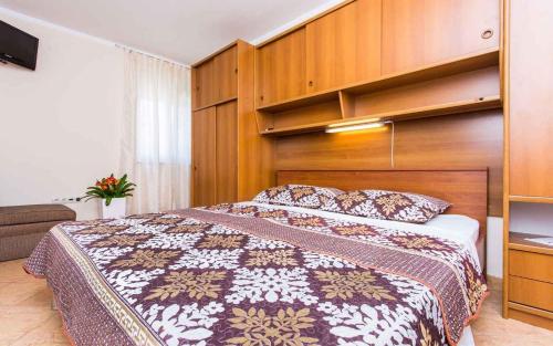 a bedroom with a large bed with a wooden headboard at Apartment in Vrbnik/Insel Krk 35843 in Vrbnik