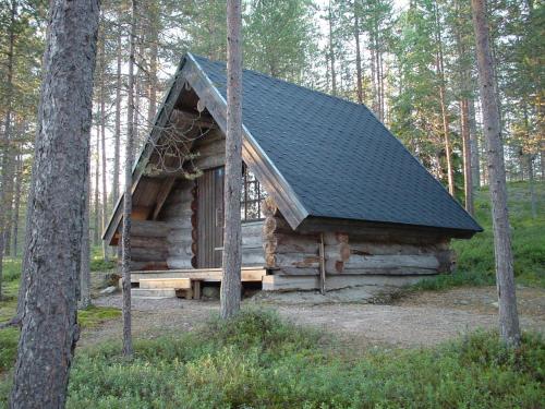 a log cabin with a black roof in the woods at Holiday Village Himmerki in Posio
