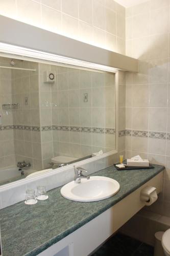 un baño con lavabo y espejo en The Clonakilty Hotel, en Clonakilty