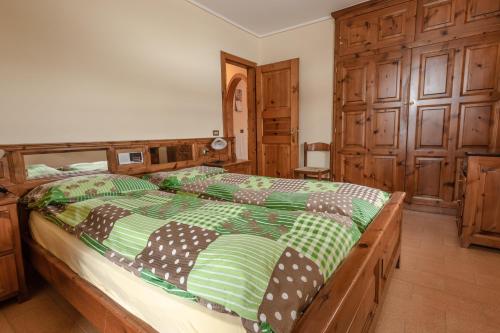 una camera con un grande letto con struttura in legno di Baita Nicoló a Livigno