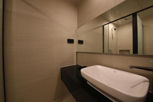 a bathroom with a sink and a mirror at Zam101 Hotel Gimhae in Gimhae