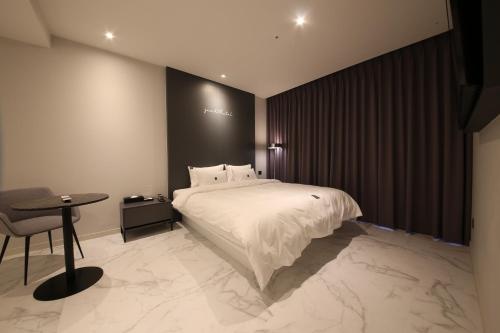 a bedroom with a bed and a table and a chair at Zam101 Hotel Gimhae in Gimhae