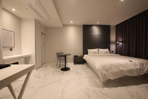 a bedroom with a bed and a desk and a chair at Zam101 Hotel Gimhae in Gimhae