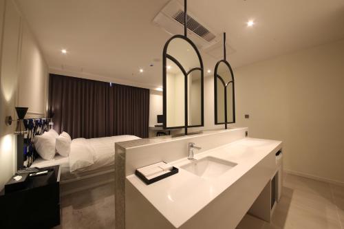 a bathroom with a sink and a bed at Zam101 Hotel Gimhae in Gimhae