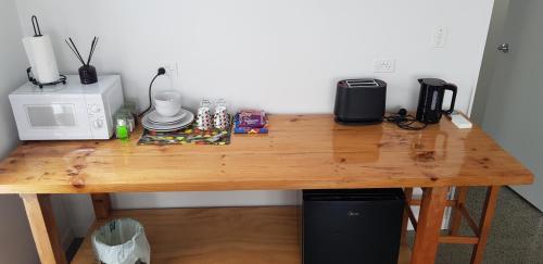 a wooden table with a microwave oven and a microwave at The Kingsland Suite in Auckland