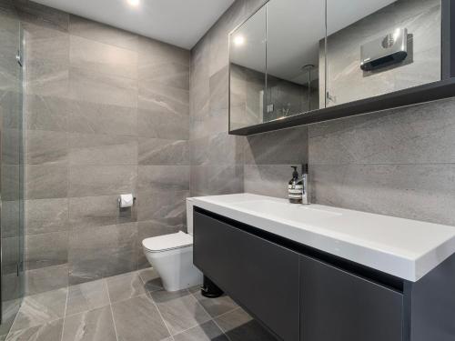 a bathroom with a white sink and a toilet at The Bunker Alpha B in Queenstown