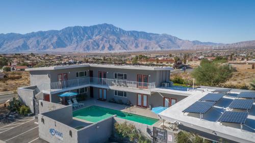 una casa con piscina y montañas al fondo en Desert Hot Springs Inn, en Desert Hot Springs