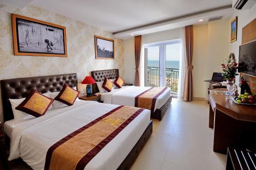 a hotel room with two beds and a balcony at Boss Hotel in Nha Trang