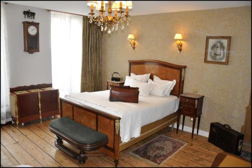 ein Schlafzimmer mit einem Bett, einem Stuhl und einer Uhr in der Unterkunft Detective Hotel in Étretat