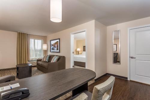 a living room with a table and a room with a bed at Candlewood Suites Bensalem - Philadelphia Area by IHG in Bensalem