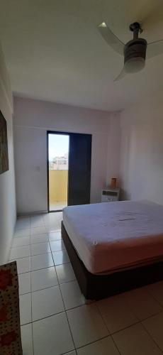 ein Schlafzimmer mit einem großen Bett und einem Fenster in der Unterkunft Guarujá praia da Enseada in Guarujá