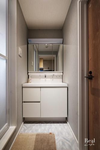 a bathroom with a white sink and a mirror at Real Life SANGENJAYA in Tokyo
