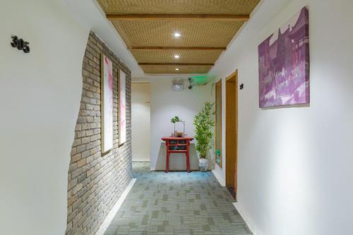 a hallway with a table and a brick wall at Xi'an Travelling with Hotel South Gate in Xi'an