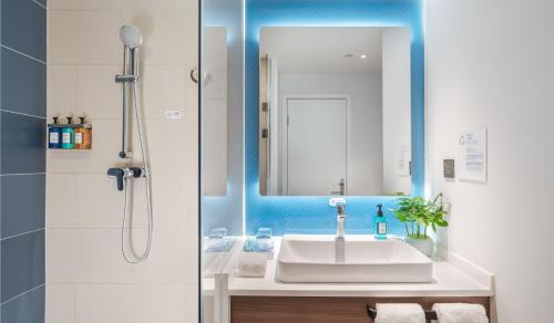 a bathroom with a sink and a mirror at Holiday Inn Express Changsha Shifu, an IHG Hotel in Changsha