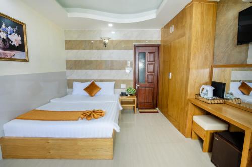 a hotel room with two beds and a television at Oliver Hotel in Nha Trang