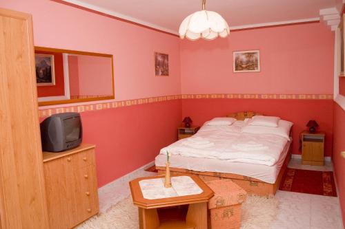 a bedroom with a bed and a tv in it at Erdős Apartments in Mosonmagyaróvár