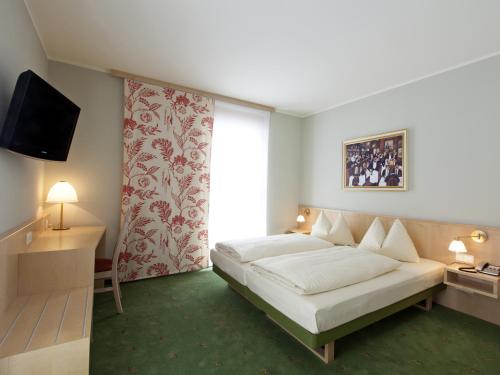 a hotel room with a bed and a television at Landzeit Tauernalm in Flachau
