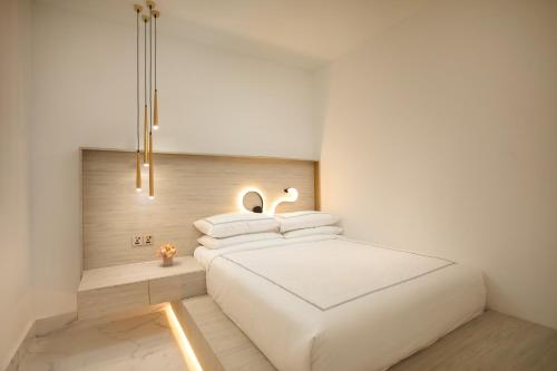 a bedroom with a white bed with two pillows at arte by Thomas Chan in Kuala Lumpur