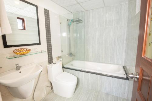芽莊的住宿－Oliver Hotel，浴室配有盥洗盆、卫生间和浴缸。