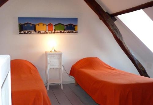 a bedroom with two beds and a painting on the wall at Violette avec parking privé sécurisé in Saint-Valery-sur-Somme