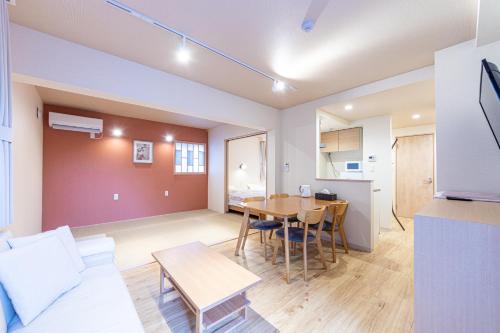 VACATION INN HEIWAJIMA I في طوكيو: غرفة معيشة مع طاولة ومطبخ