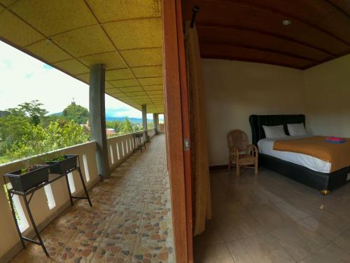 a bedroom with a bed and a balcony at PIAS POPPIES HOTEL in Rantepao