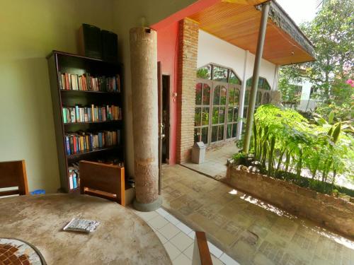 a living room with a table and a book shelf at PIAS POPPIES HOTEL in Rantepao