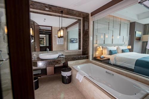 a bathroom with a tub and a bed and a sink at Crowne Plaza Bandung by IHG in Bandung