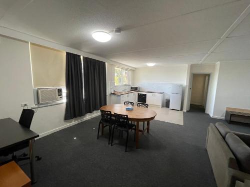 a room with a table and chairs and a kitchen at Parkside Inn Motel in Melbourne