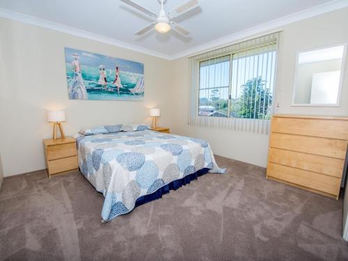 a bedroom with a bed and a ceiling fan at Collendina 15 19 Kurrawa Close water views and wifi in Nelson Bay