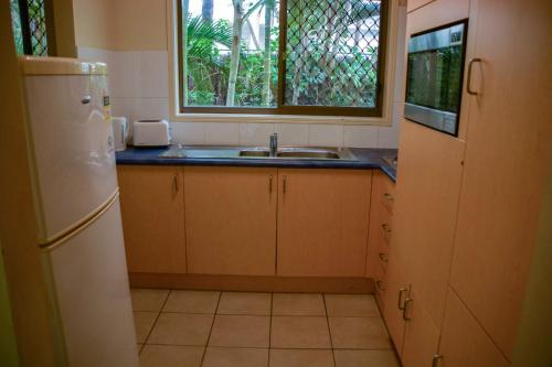 a kitchen with a sink and a refrigerator at Maxmee Backpackers Resort in Gold Coast