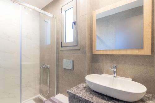 La salle de bains est pourvue d'un lavabo et d'une douche en verre. dans l'établissement MEDITERRANEO, à Skala Potamias