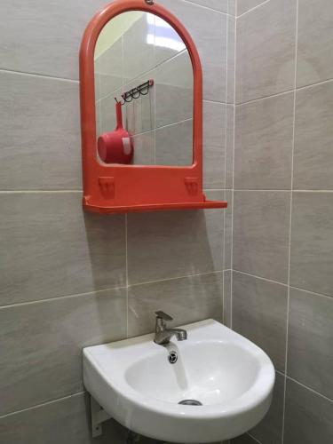 a bathroom with a red mirror and a sink at VILLA SENTOSA in Kuala Terengganu
