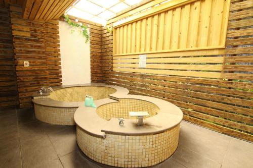 a bathroom with three sinks in a room with wooden walls at Hotspring World Wulai in Wulai